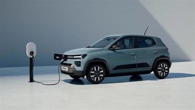 Dacia Spring vozilo modrozeleno stranski profil med polnjenjem v studiu