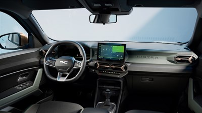 Pogled na notranjost vozila Dacia z volanom in sredinskim zaslonom multimedijskega sistema.
