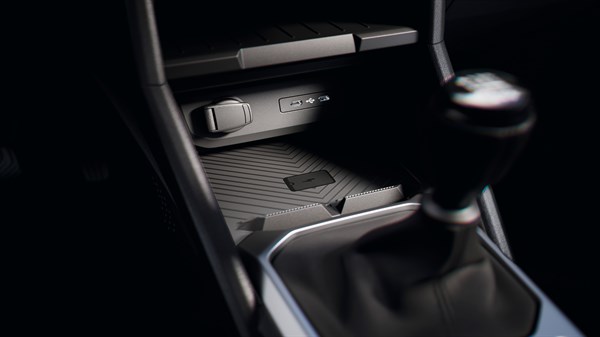 Predel z menjalnikom vozila Dacia s prikazom USB vhoda, vtiča in brezžične polnilne površine.