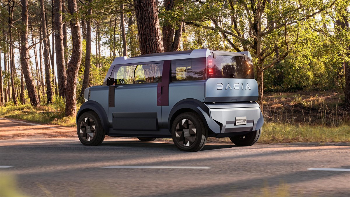Dacia Hipster, električni konceptni avto, parkiran na cesti ob gozdu v sončnem dnevu.