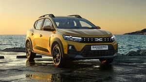 Dacia Sandero Stepway rumeno sprednji tričetrtinski pogled ob morju pri sončnem zahodu
