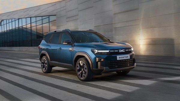 Dacia Bigster modro sprednji stranski pogled pred sodobno stavbo