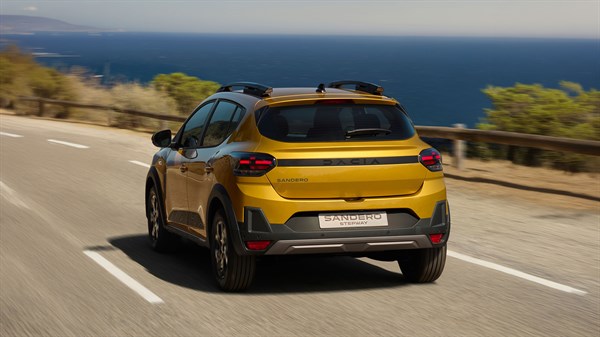 Dacia Sandero Stepway rumene barve, zadnji pogled med vožnjo po obalni cesti.
