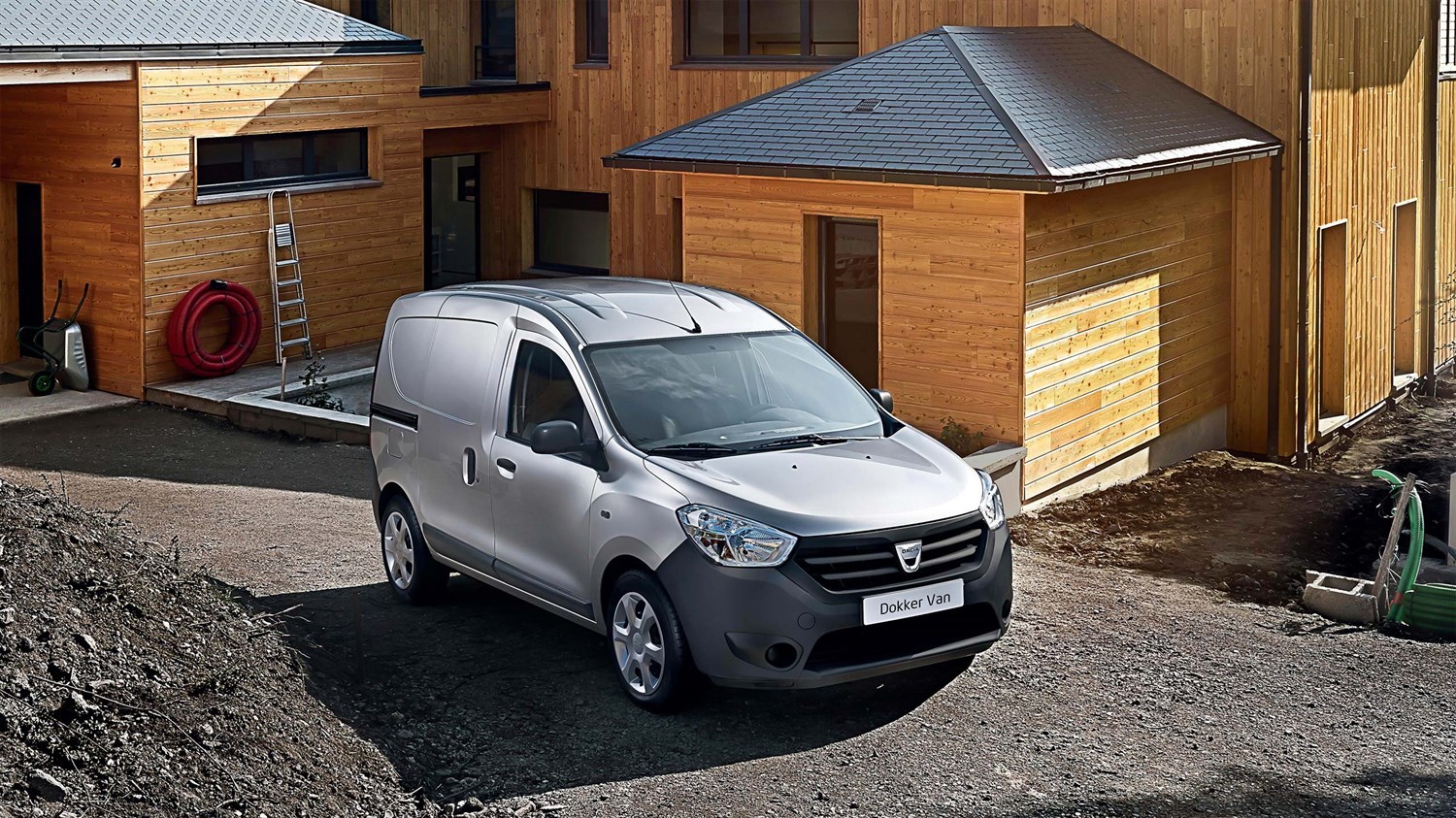 Dacia Dokker Van siva barva, sprednji bočni pogled pred leseno hišo