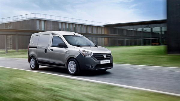 Dacia Dokker Van siva barva, sprednji bočni pogled na cesti ob moderni stavbi