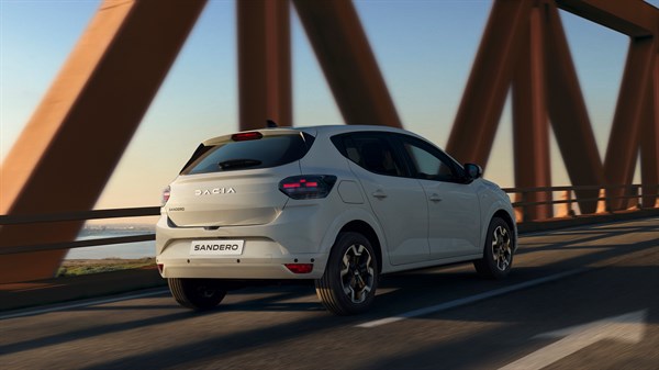 Beli Dacia Sandero zadnji pogled pri vožnji čez most.