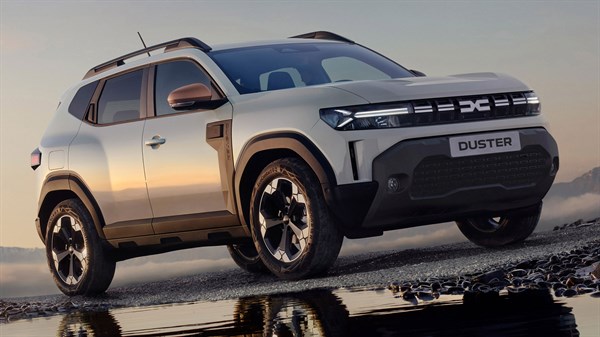 Svetlo sivi Dacia Duster slikan od spredaj na cesti.