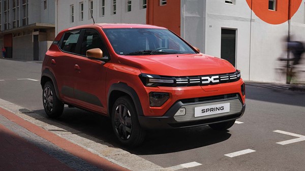 Dacia Spring vozilo oranžno sprednji stranski pogled na cesti