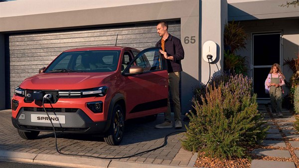 Dacia Spring vozilo rdeče polnjenje pred hišo