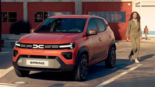 Dacia Spring vozilo oranžno sprednji pogled na parkirišču