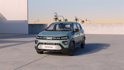 Dacia Spring vozilo zeleno sprednji pogled ob sončnem zahodu