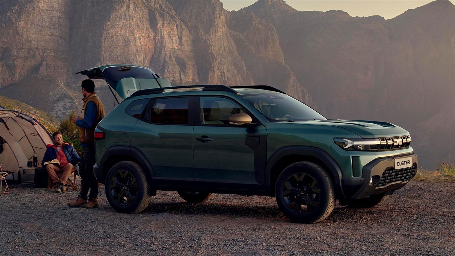 Zeleni Dacia Duster bočni profil z odprtim prtljažnikom v gorskem okolju
