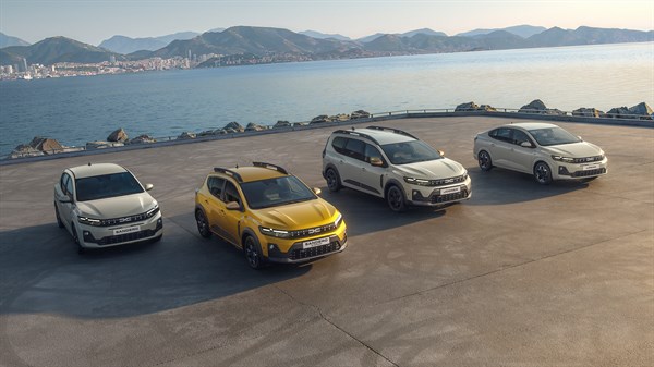 Štiri vozila Dacia Sandero, Sandero Stepway, Jogger in Duster na parkirišču ob morju.