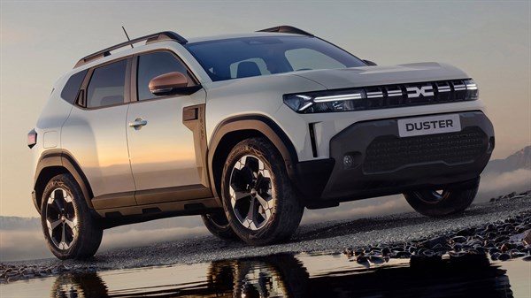 Svetlo sivi Dacia Duster bočni profil ob vodi pri sončnem zahodu