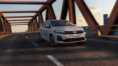 Dacia Sandero vozilo belo sprednji profil na mostu ob sončnem zahodu