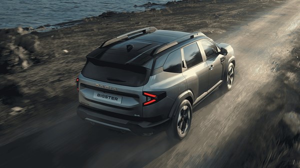 Dacia Bigster vozilo sivo pogled od zadaj na makadamski poti ob morju