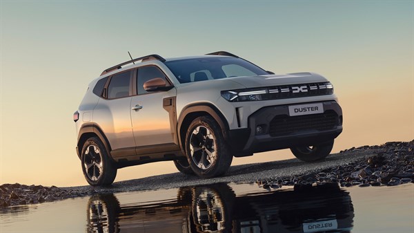 Dacia Duster vozilo belo sprednji profil ob vodi ob sončnem zahodu