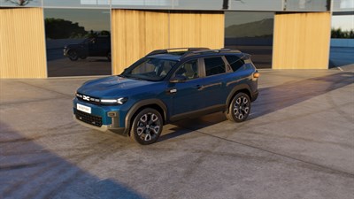 Oranžni Sandero STepway parkiran preh hišo, dekle v ozadju