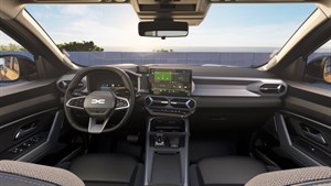 Notranjost vozila Dacia z modernim dizajnom armaturne plošče, digitalnim prikazovalnikom za volanom in osrednjim zaslonom na dotik. 