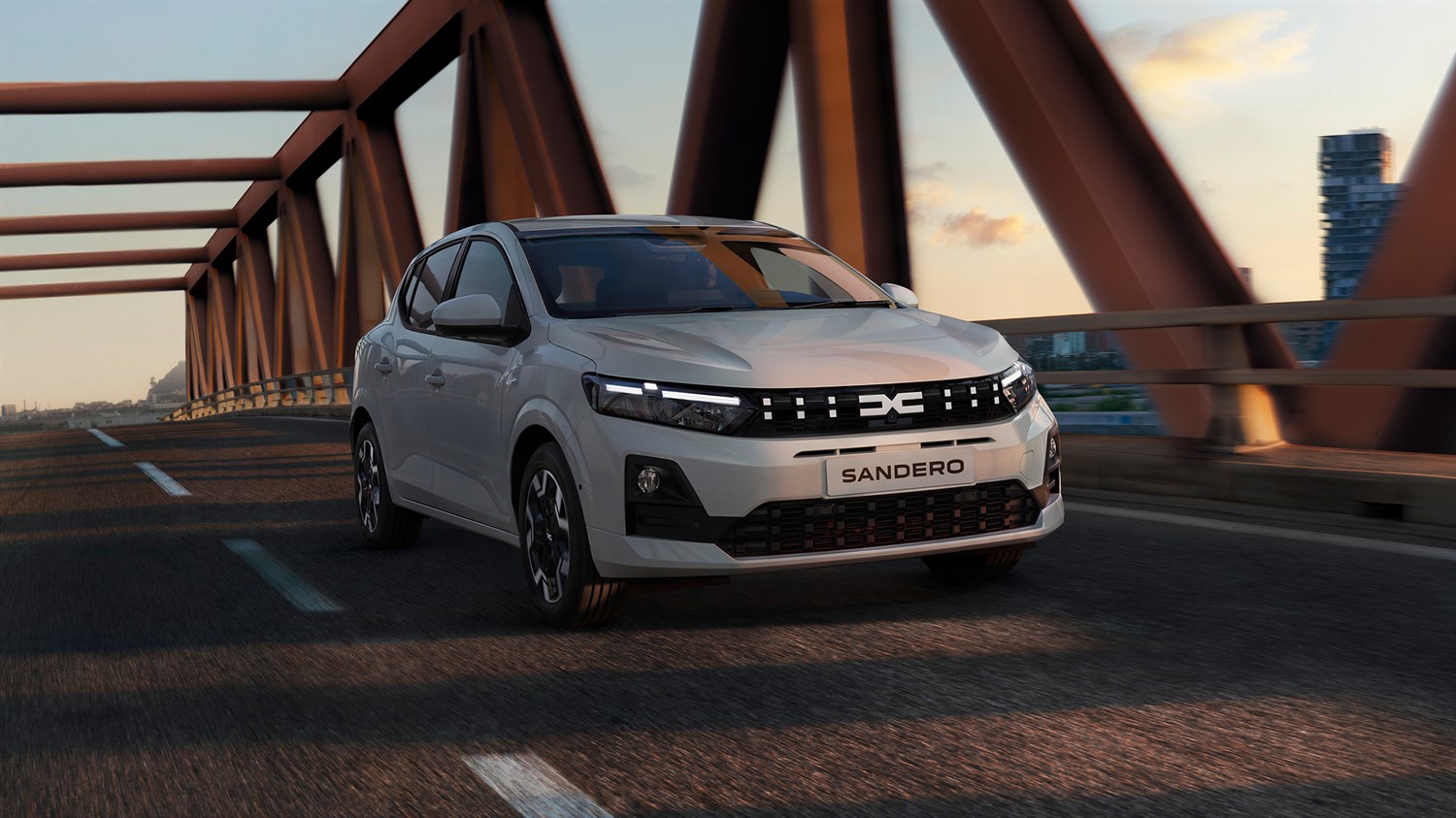 Temnozeleni Dacia Sandero v vožnji preko mostu.