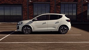 Na sliki je bel mestni avtomobil Sandero s petimi vrati, prikazan v bočnem pogledu.