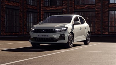 Beli Dacia Sandero parkiran v mestu.