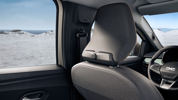 Fotografija prikazuje zadnji del sprednjega sedeža v Dacii Sandero Stepway, z izrazito oblikovanim vzglavnikom in vgrajenim nosilcem za obešanje predmetov.