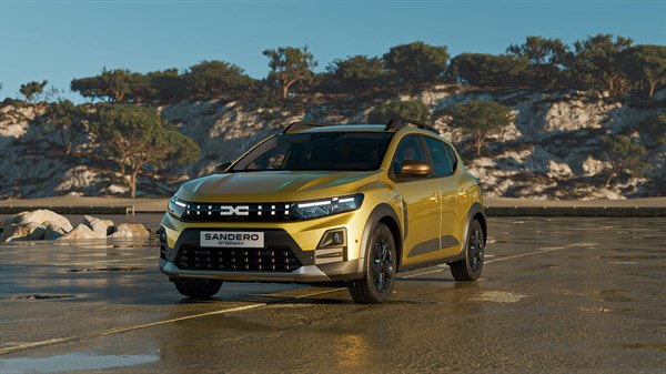 Na sliki je rumen Dacia Sandero Stepway v vožnji po ravni, svetli cesti sredi odprte pokrajine.