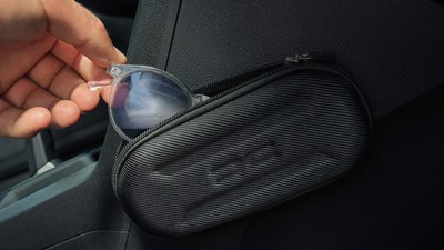 Na sliki je prikazana črna torbica, kot etui za očala in dodatni prostor za hrambo osebnih predmetov.