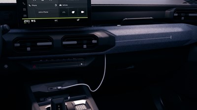 Notranjost vozila Dacia Striker s prostorom za napeljavo kabla polnilnika telefona.