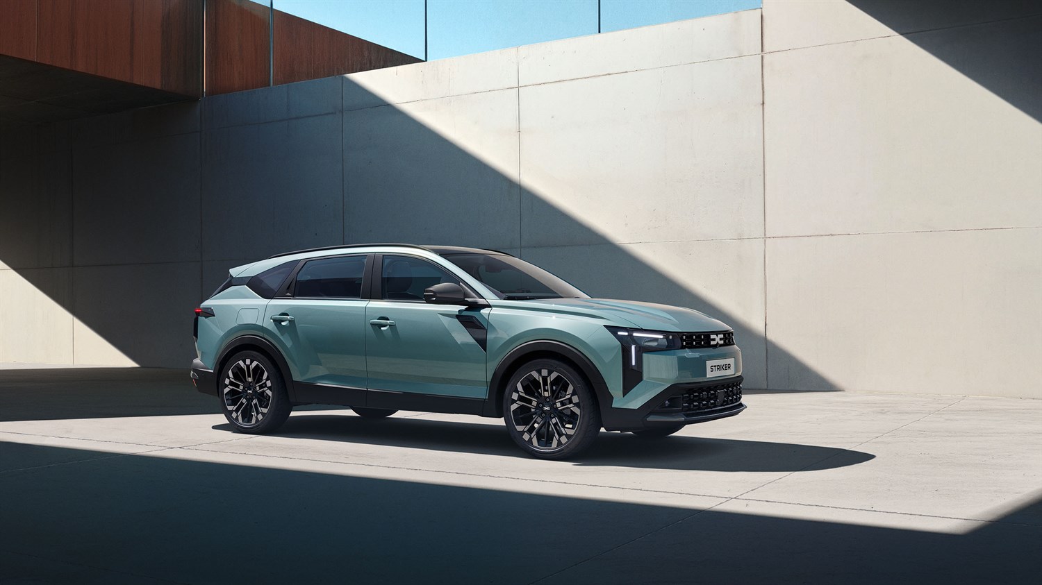 Dacia Striker, pogled od spredaj na mestni SUV pred moderno arhitekturo.