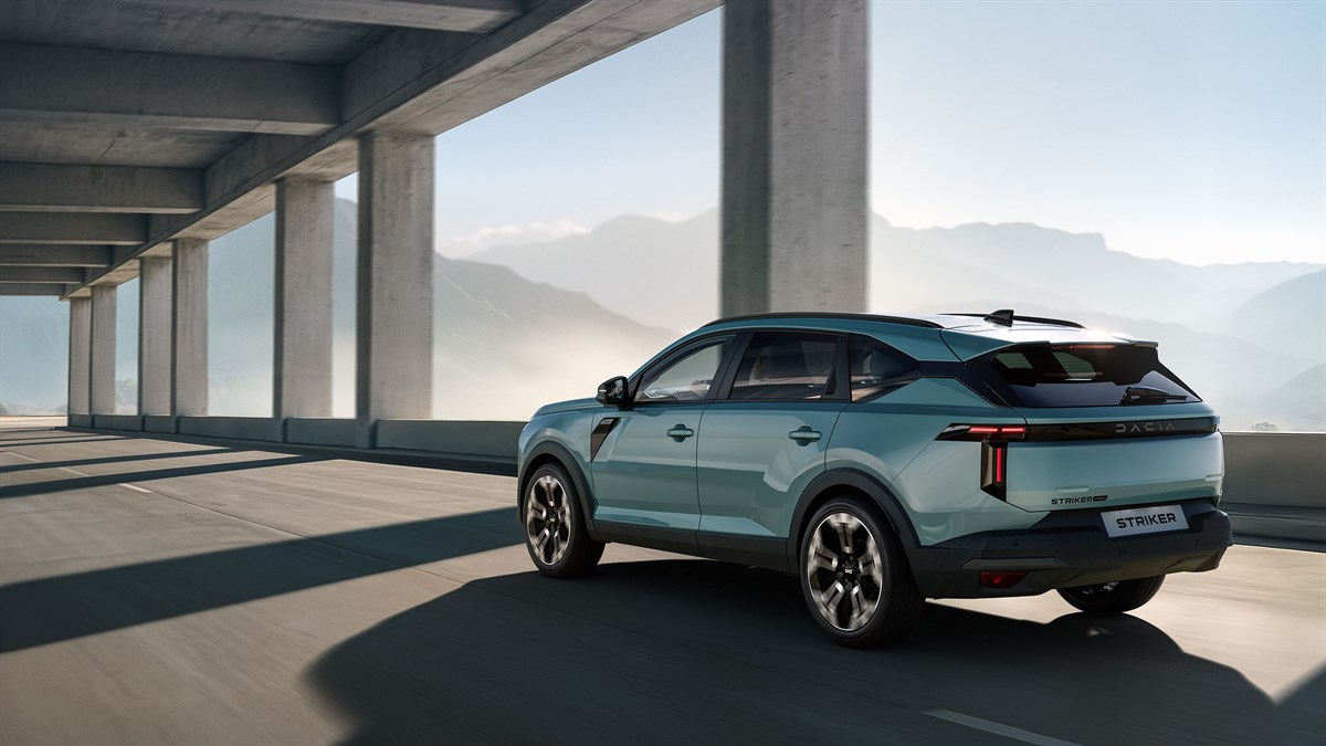 Dacia Striker, pogled od zadaj med vožnjo skozi moderno betonsko arhitekturo.