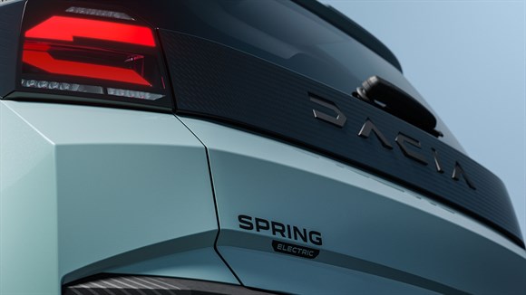 Modri Dacia Spring, zadnji del vozila z logotipom in zadnjo lučjo.