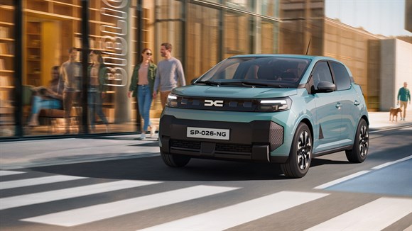 Dacia Spring v svetlo modri barvi med vožnjo po mestni ulici