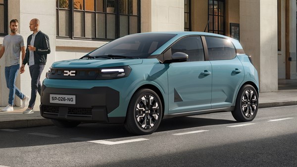 Dacia Spring v svetlo zeleni barvi, parkiran ob mestni ulici