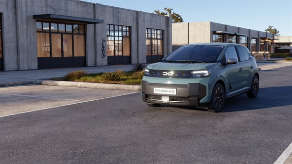 Dacia Spring v svetlo modri barvi med vožnjo po mestni ulici