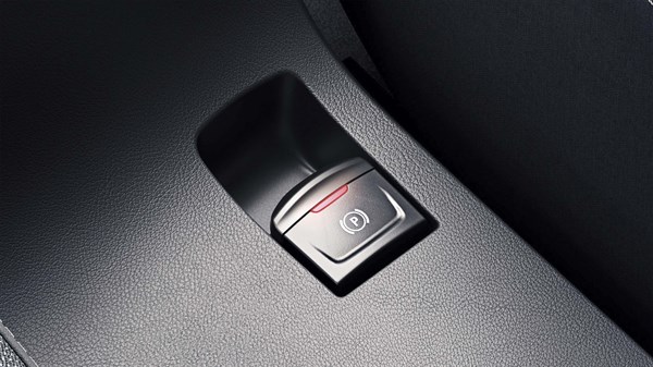 Elektronska ročna zavora v vozilu Dacia Jogger, prikazana od blizu z osvetljenim indikatorjem za aktivirano zavoro.