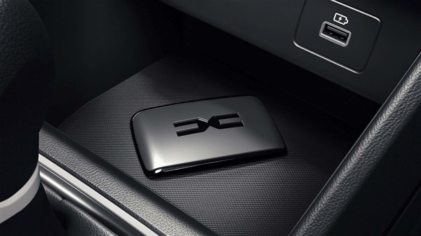 Ključ z logotipom Dacia leži na sredinski konzoli vozila, poleg vhoda USB in površine za brezžično polnjenje.