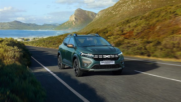 Zeleni Sandero Stepway ob gorski poti, v ozadju jezero.