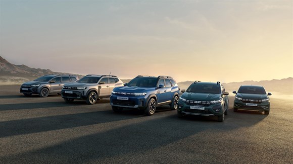 Siv Dacia Jogger vozi po cesti skozi puščavsko pokrajino.